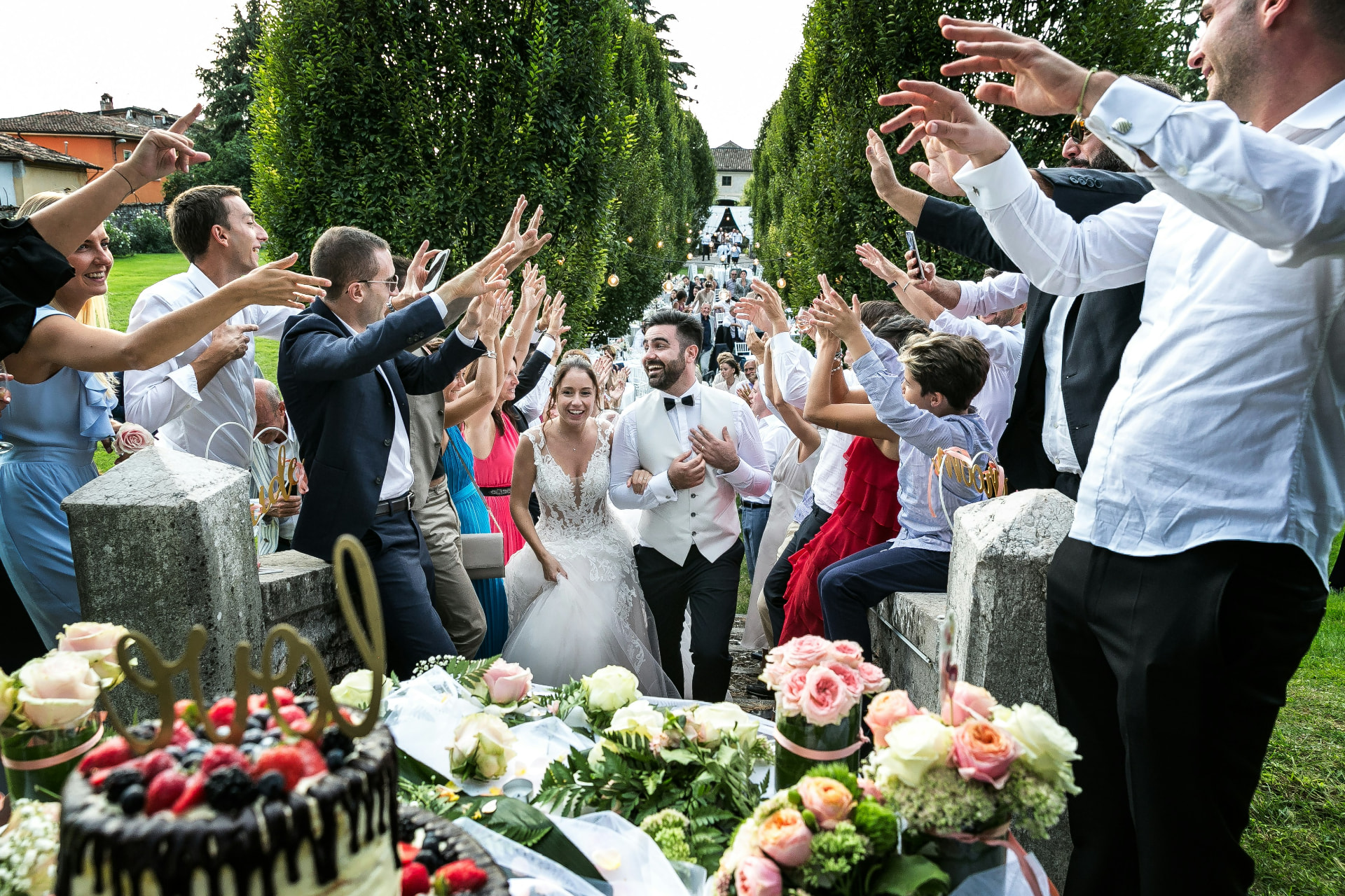 Bride and groom walking through cheering guests at an outdoor wedding reception